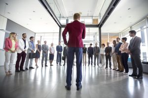 Business leader hold meeting with his team and tell them situation